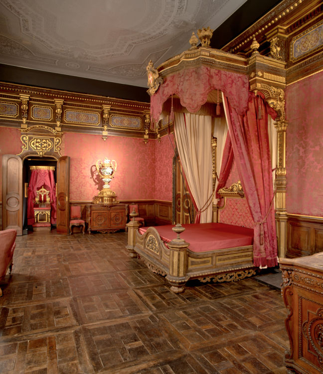 Foto di Ernani Orcorte<br>La Camera da Letto della Regina Maria Adelaide, moglie di Vittorio Emanuele II, fu decorata intorno al 1852, dall’équipe dell’ebanista Gabriele Capello, sotto la direzione di Domenico Ferri. Su uno dei due cassettoni presenti nella sala è collocato il grandioso vaso in porcellana di Meissen, con fiori a palla di neve e uccelli, di Johann Joachim Kandler, acquistato dal re all’Esposizione Nazionale del 1858.